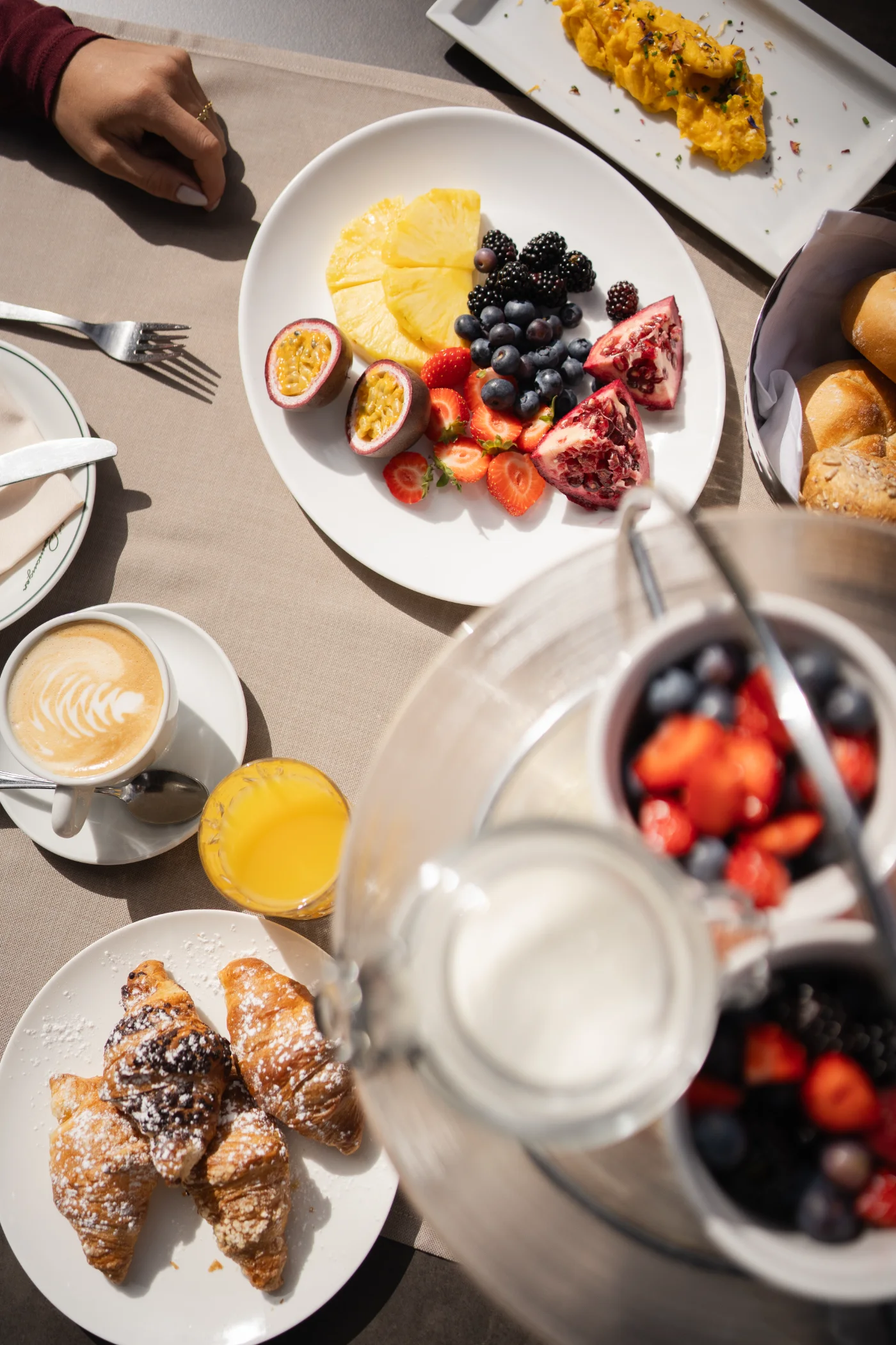 Croissants, Obst und Joghurt am Frühstückstisch