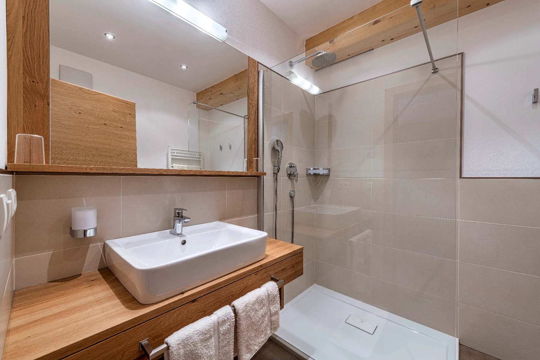 Badezimmer mit Regendusche und Naturholzelementen