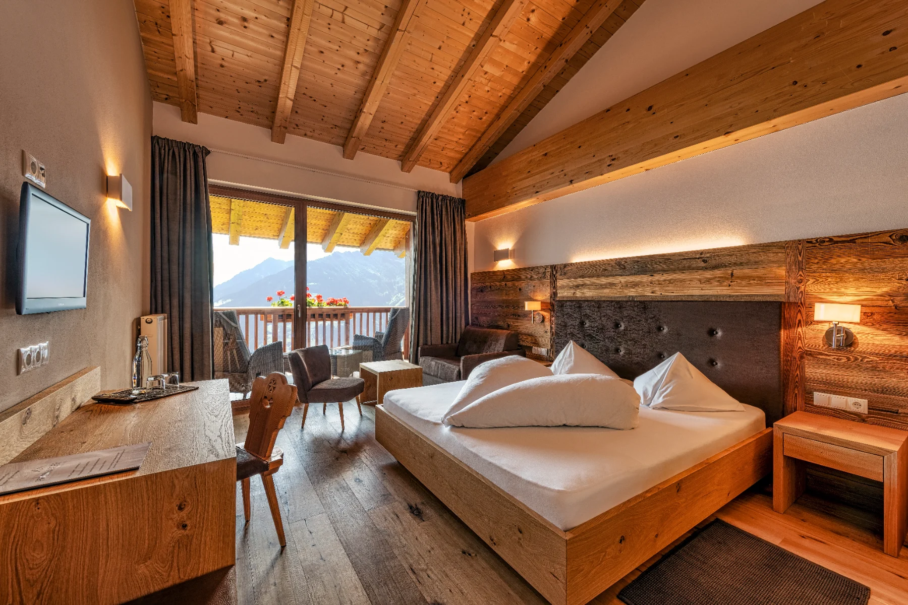 Zimmer mit bodentiefen Fenstern und Blick auf die Berge